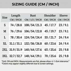 May include: A black and white sizing guide chart featuring columns for size, length, bust, shoulder, and sleeve measurements in both centimetres and inches. The table lists sizes from S to 3XL with specific numerical values and a disclaimer note.