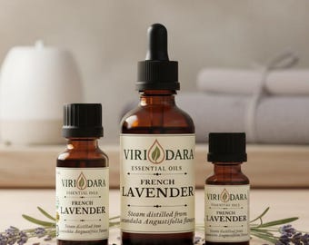 May include: Three amber glass bottles of French lavender essential oil with black caps. The bottles are labeled "Viri Dara Essential Oils" and "French Lavender." Lavender sprigs and a diffuser are in the background.