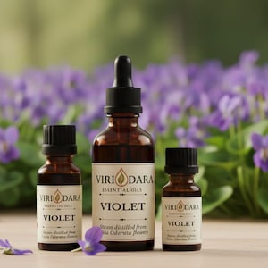 May include: Three amber glass essential oil bottles with black caps. The bottles are labeled "Viri Dara Essential Oils Violet". The background features purple flowers and a wooden surface.