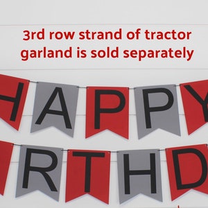 May include: Red and gray happy birthday banner with black letters. The banner is strung with red toy tractors. The text "3rd row strand of tractor garland is sold separately" is at the top of the image.