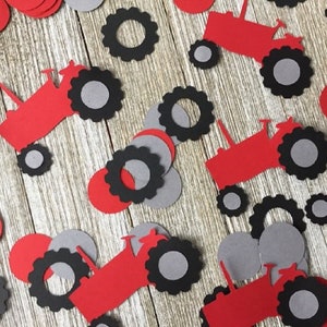 May include: Red and black paper tractor cutouts with gray circles. These are party decorations for a farm-themed party.