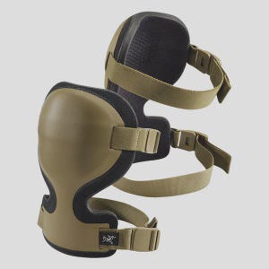 Könnte beinhalten: Zwei olivgrüne Knieschützer mit schwarzer Polsterung und verstellbaren beigefarbenen Riemen. Die Pads haben ein gebogenes Design zum Schutz der Knie und verfügen über Schnallenverschlüsse. Das Bild zeigt die Pads vor einem hellgrauen Hintergrund.