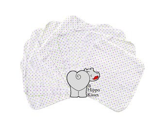 Pode incluir: Um conjunto de seis toalhas brancas com um padrão de bolinhas roxas e verdes. As toalhas têm uma borda festonada e apresentam um hipopótamo cinza com um coração vermelho e o texto "Hippo Kisses".