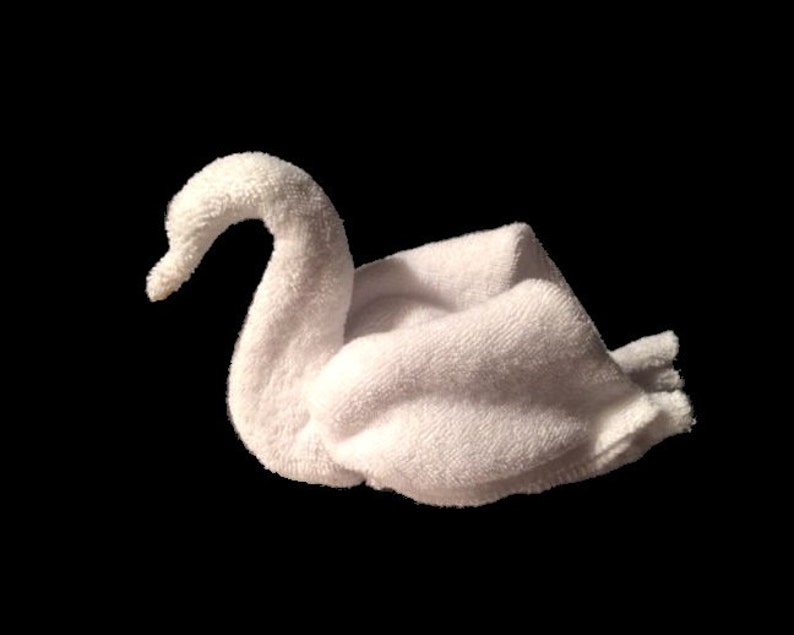 May include: A white towel folded into the shape of a swan. The swan is facing the right side of the image.