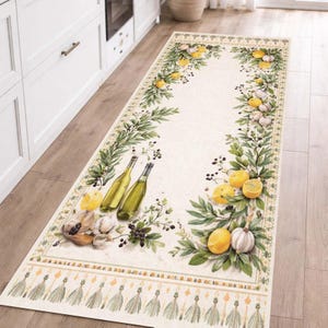 May include: Cream-colored kitchen runner rug with a botanical design featuring lemons, garlic, and olive branches. Two green wine bottles are also depicted. The rug has a decorative border and tassels along the bottom edge.