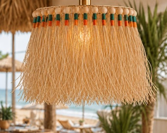 Lámpara colgante de rafia hecha a mano, estilo bohemio playero, con cuentas de madera y herrajes dorados.