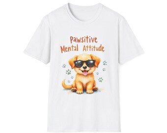May include: White t-shirt featuring a cartoon golden retriever wearing sunglasses. The shirt has the text "Pawsitive Mental Attitude" in orange, with paw prints around the dog. A cute and cheerful design.