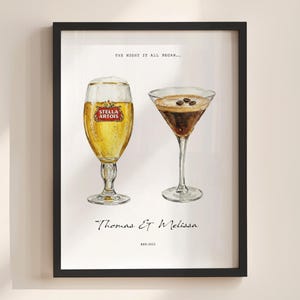 Puede incluir: Impresión artística enmarcada con ilustraciones en acuarela de una copa de cerveza Stella Artois y una copa de martini con granos de café. El texto incluye "The night it all began...", "Thomas & Melissa" y "Est. 2022".