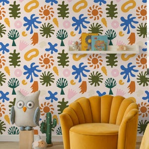 Può includere: Stanza per bambini con carta da parati a motivi colorati con forme astratte blu, verdi, arancioni e gialle. Una poltrona in velluto giallo è davanti al muro. Un gufo e un cactus di peluche sono sul pavimento.