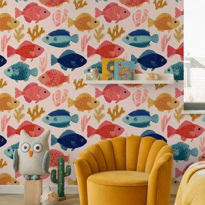 May include: A child's room with a fish-patterned wallpaper in shades of blue, red, and yellow. A yellow armchair and a rug with geometric shapes are in the foreground. A stuffed owl and cactus are also visible.