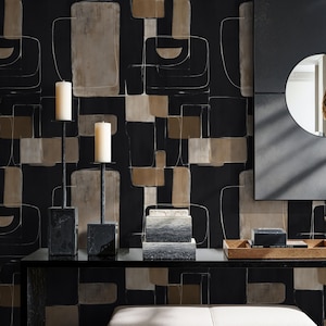 Può includere: Una scena d'interni moderna con una consolle nera e oggetti decorativi. Due candele bianche sono su candelabri in metallo nero. Lo sfondo è una carta da parati geometrica nera e beige, con uno specchio a destra.