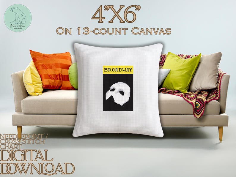 May include: A white square cushion with a cross-stitch design. The design features the word "BROADWAY" above a black rectangle with a white mask. The cushion is 10.16cm x 15.24cm on a 13-count canvas. Text reads "NEEDLEPOINT/ CROSS STITCH CHART DIGITAL DOWNLOAD".
