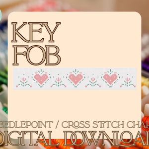 May include: A digital cross stitch chart for a key fob featuring a repeating pattern of pink hearts and small green floral motifs on a white grid. The text reads KEY FOB and NEEDLEPOINT / CROSS STITCH CHART DIGITAL DOWNLOAD in brown lettering.