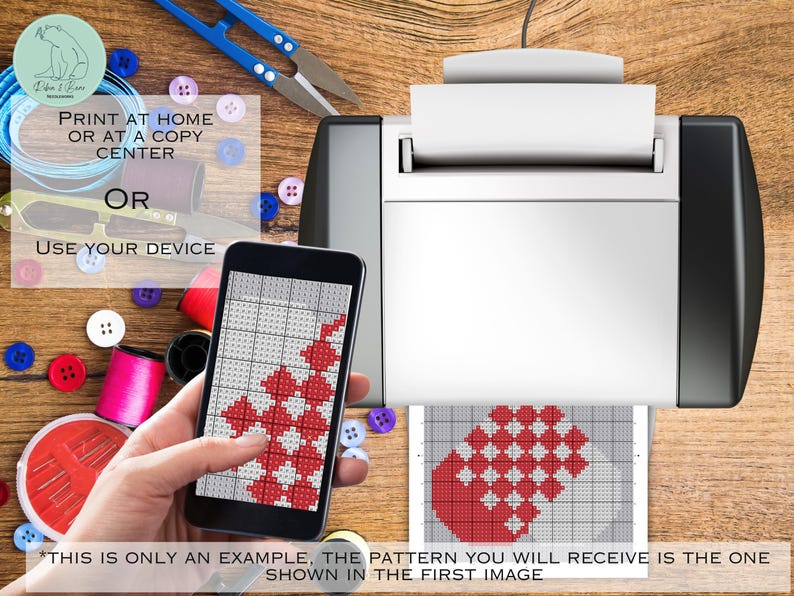 May include: A smartphone shows a red and white cross-stitch design, with a printed version from a printer. Sewing supplies such as scissors, buttons, and thread spools are visible. Text reads: "PRINT AT HOME OR AT A COPY CENTER OR USE YOUR DEVICE."