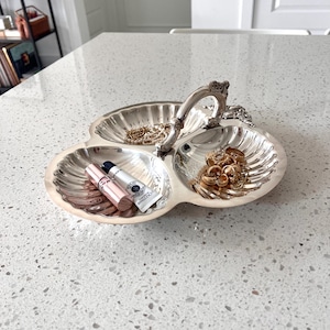 May include: A set of three ceramic mugs with a speckled, matte finish. The mugs are in shades of cream, light gray, and dark gray. Each mug has a simple, minimalist design, perfect for coffee or tea.