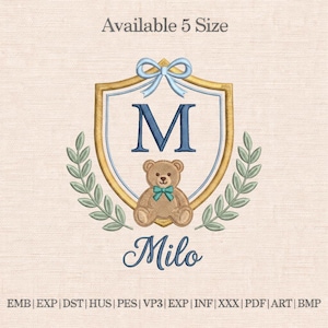 Può includere: Design ricamato con uno scudo, bordo dorato, fiocco blu e la lettera "M". Un orsacchiotto con papillon blu è sotto la lettera. Il nome "Milo" è scritto sotto l'orso. Il testo "Available 5 Size" è in alto.