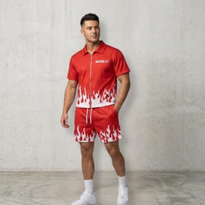 May include: A red short-sleeved collared shirt with a full-length front zip and white flame patterns at the hem, paired with matching red shorts featuring a white flame design at the bottom. The shirt displays the text MAKERS FIT in white.