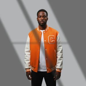 May include: Orange and white varsity jacket with a large white letter "C" patch on the chest. The jacket has white sleeves, a white collar, and white stripes on the cuffs and hem. The jacket is buttoned up.