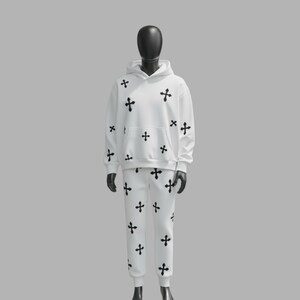 May include: White hoodie and sweatpants set with a black cross pattern. The hoodie has a front pocket and a hood. The sweatpants have an elastic waistband and cuffs. The outfit is displayed on a mannequin.