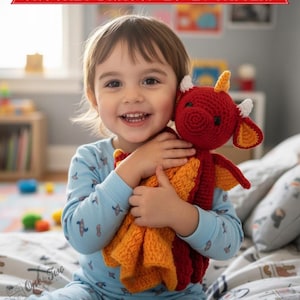 May include: A crochet dragon lovey featuring a red head with white horns, a yellow horn, and orange ears. The body is a textured orange blanket. The text CROCHET DRAGON LOVEY PATTERN is displayed in a red banner at the top of the image.