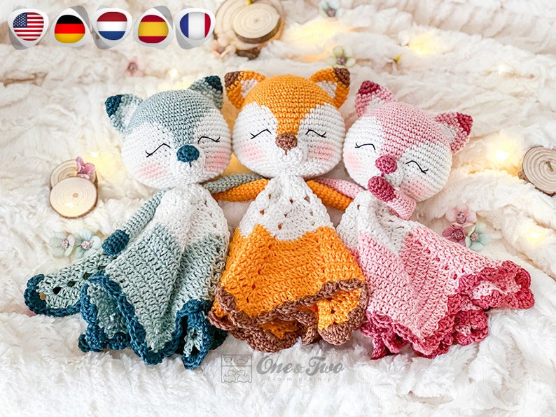 May include: Three crocheted fox and wolf security blankets. The fox blankets are orange and white, the wolf blanket is blue and white. Each has a smiling face with closed eyes. The blankets have a scalloped edge.