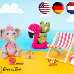 May include: A crocheted elephant wearing a pink swimsuit, a crocheted frog riding a pink flamingo float, a sandcastle, a bucket and spade, a deckchair, a beach ball, and a red crab on a yellow sandy beach.