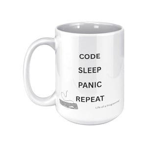 May include: White ceramic mug with the words "CODE SLEEP PANIC REPEAT" in black, along with a keyboard graphic. The phrase "Life of a Programmer" is printed at the bottom. The mug has a large handle.
