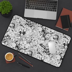 Puede incluir: Alfombrilla de escritorio rectangular en blanco y negro con una ilustración de estilo anime. La alfombrilla se muestra con un ordenador portátil, un ratón y otros accesorios de escritorio.