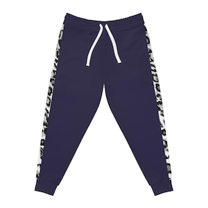 Könnte beinhalten: Marineblaue Jogginghose mit weißem Kordelzug und einem schwarz-weißen Animal-Print-Streifen an den Seiten. Die Jogginghose hat eine lockere Passform und ist aus einem weichen Material gefertigt.