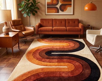 May include: A rectangular area rug featuring a thick, plush texture with a repeating wave pattern in shades of cream, orange, rust, and dark brown. The design consists of curved, flowing lines that span the length of the rug, creating a bold, rhythmic visual effect across the floor surface.