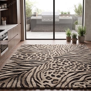 May include: A rectangular area rug featuring a high-contrast animal print pattern that combines dark brown leopard spots and beige zebra stripes. The rug has a textured, carved pile design that creates a three-dimensional effect across the surface.