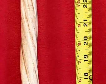 May include: A light-colored, carved wooden wand with a spiral design, approximately 35 inches long, is displayed against a red background. A yellow measuring tape is positioned next to the wand for scale.