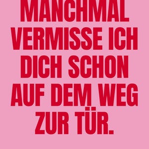 May include: A rectangular poster with a light pink background featuring bold red text that reads: MANCHMAL VERMISSE ICH DICH SCHON AUF DEM WEG ZUR TÜR. At the bottom, the small red text reads: WWW.DUNKELROT.DE.