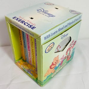 May include: A Disney Winnie the Pooh Exercise box set containing multiple books and a Learn-Aloud and Musical Fun CD. The light blue and green packaging features illustrations of Pooh, Piglet, and Tigger, with the text Pooh and Friends Exercise.