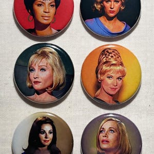 May include: A set of three ceramic mugs with a speckled, matte finish. Each mug features a different color: light blue, cream, and gray. The mugs have a simple, modern design and a comfortable handle.