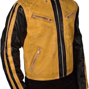 Könnte beinhalten: Senfgelbe und schwarze Lederjacke mit Stehkragen und Reißverschluss. Die Jacke hat schwarze Ärmel mit zwei gelben Streifen und zwei Reißverschlusstaschen auf der Brust.
