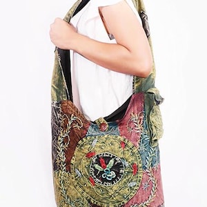 Pode incluir: Bolsa de ombro grande e colorida com um design bordado. A bolsa apresenta uma mistura de tecidos verdes, castanhos e bordô com intrincados padrões florais e geométricos. Possui uma alça longa e um compartimento principal grande.