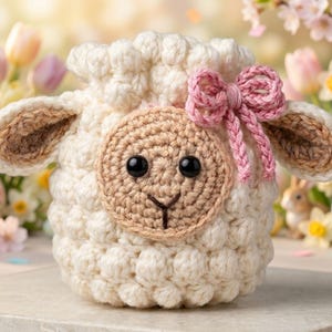 Può includere: Borsa fatta a mano all'uncinetto a forma di agnello, nei colori crema, marrone e rosa. L'agnello ha un viso rotondo con occhi neri, naso e orecchie marroni. Un fiocco rosa adorna la parte superiore. Ideale per Pasqua o la primavera.