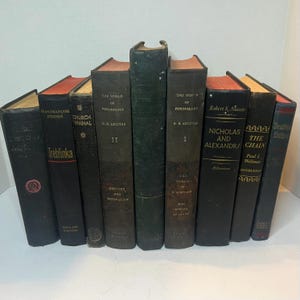 May include: A selection of vintage books with diverse titles and colours. The spines are mainly dark, with some featuring red or tan accents. Titles include "The World of Psychology," "Nicholas and Alexandra," and "Treblinka."