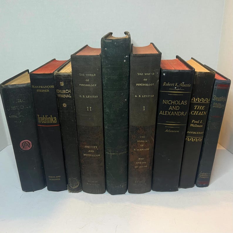 May include: A selection of vintage books with diverse titles and colours. The spines are mainly dark, with some featuring red or tan accents. Titles include "The World of Psychology," "Nicholas and Alexandra," and "Treblinka."