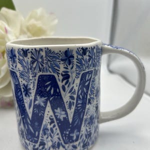 Monogram pieśni ludowej Anthropologie w kształcie litery „W” na obu kubkach. Niebiesko-biały wzór kwiatowy. zdjęcie 3