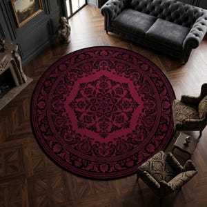 May include: A large circular area rug featuring a deep burgundy red background with an intricate black damask floral pattern. The design includes a central medallion surrounded by ornate scrolling leaves and symmetrical botanical motifs.