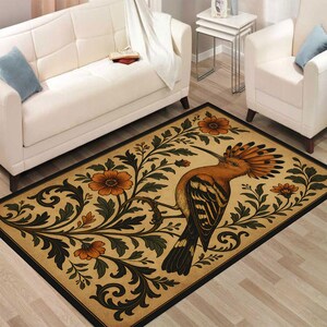 May include: Rectangular rug with a Hoopoe bird illustration, showcasing an orange crest and patterned wings, set against floral and foliage patterns. The rug has a tan backdrop with orange and green details, and a black border.
