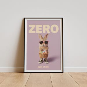 May include: A framed poster featuring a rabbit wearing sunglasses and sneakers, holding a basket of Easter eggs. The word "ZERO" is at the top, with "EGGS GIVEN" at the bottom, all against a lavender background.