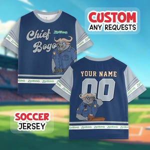 May include: Navy blue soccer jersey featuring Chief Bogo from Zootopia. The front displays the character's image and the text "Chief Bogo". The back has the text "YOUR NAME" and the number "00". The sleeves are gray.