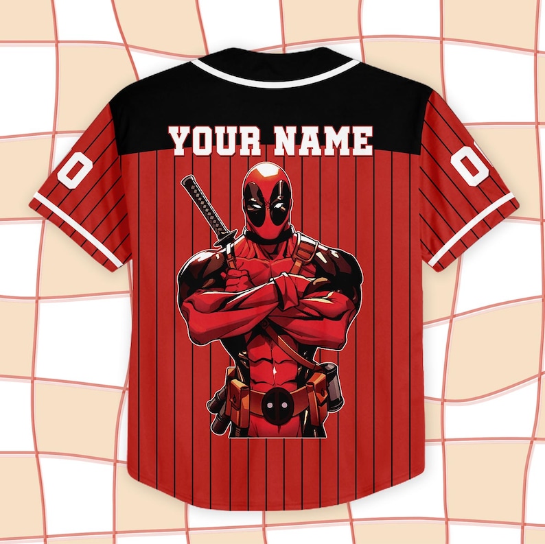K&ouml;nnte beinhalten: Rotes und schwarzes Baseball-Trikot mit dem Text "YOUR NAME" auf dem R&uuml;cken. Das Trikot zeigt eine Deadpool-Grafik auf dem R&uuml;cken und die Nummer "0" auf den &Auml;rmeln. Das Trikot hat einen schwarzen Kragen und wei&szlig;e Verzierungen.