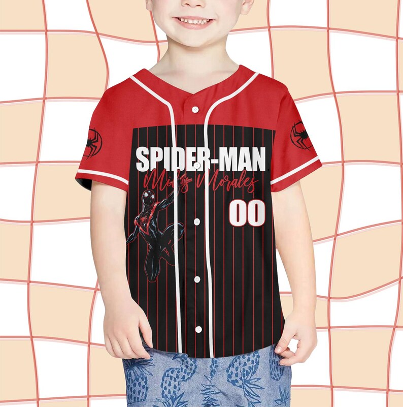 Pode incluir: Camisola de baseball vermelha e preta com o texto "SPIDER-MAN Miles Morales 00". A camisola tem detalhes brancos, um logotipo do Homem-Aranha nas mangas e um design listrado preto e vermelho na frente.
