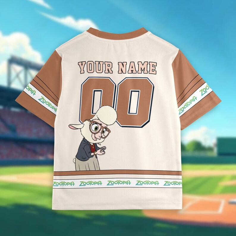 May include: Cream-colored baseball jersey with brown sleeves and trim. Features the text "YOUR NAME" above the number "00" in a brown outlined font. A cartoon sheep character wearing glasses and a suit is on the front. The sleeves have "Zootopia" text.