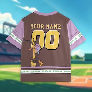 May include: Brown and lavender baseball jersey featuring a cartoon gazelle character. The jersey has the text "YOUR NAME" above the number "00" in gold. The sleeves are lavender with "Zootopia" printed on them. The bottom of the jersey also has "Zootopia" printed on it.
