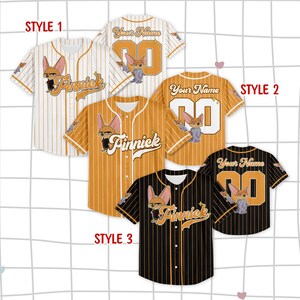 May include: Baseball jerseys in three styles: white with orange stripes, orange with white stripes, and black with orange stripes. Each jersey features a cartoon fox character and the name "Finnick" or customizable text.